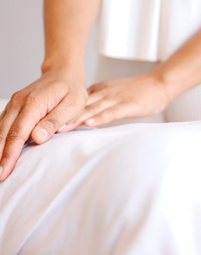 Manos aplicando Reiki en el vientre
